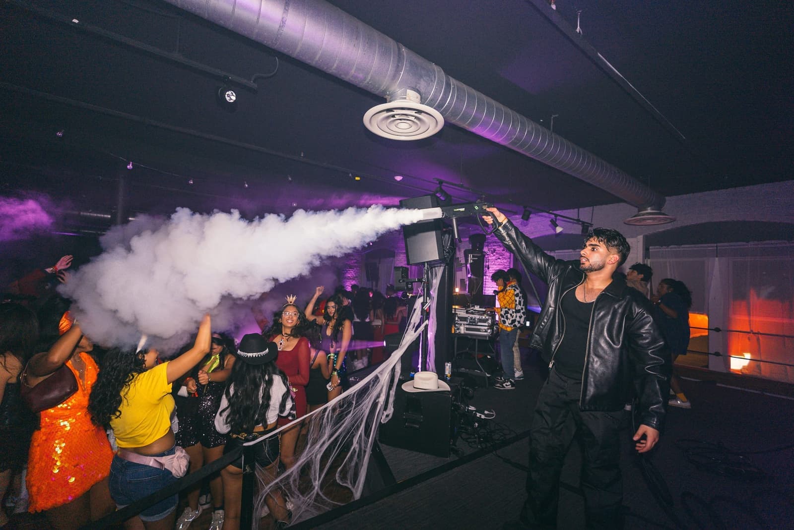 Amped crew member blasting a CO2 cannon over a packed dance floor