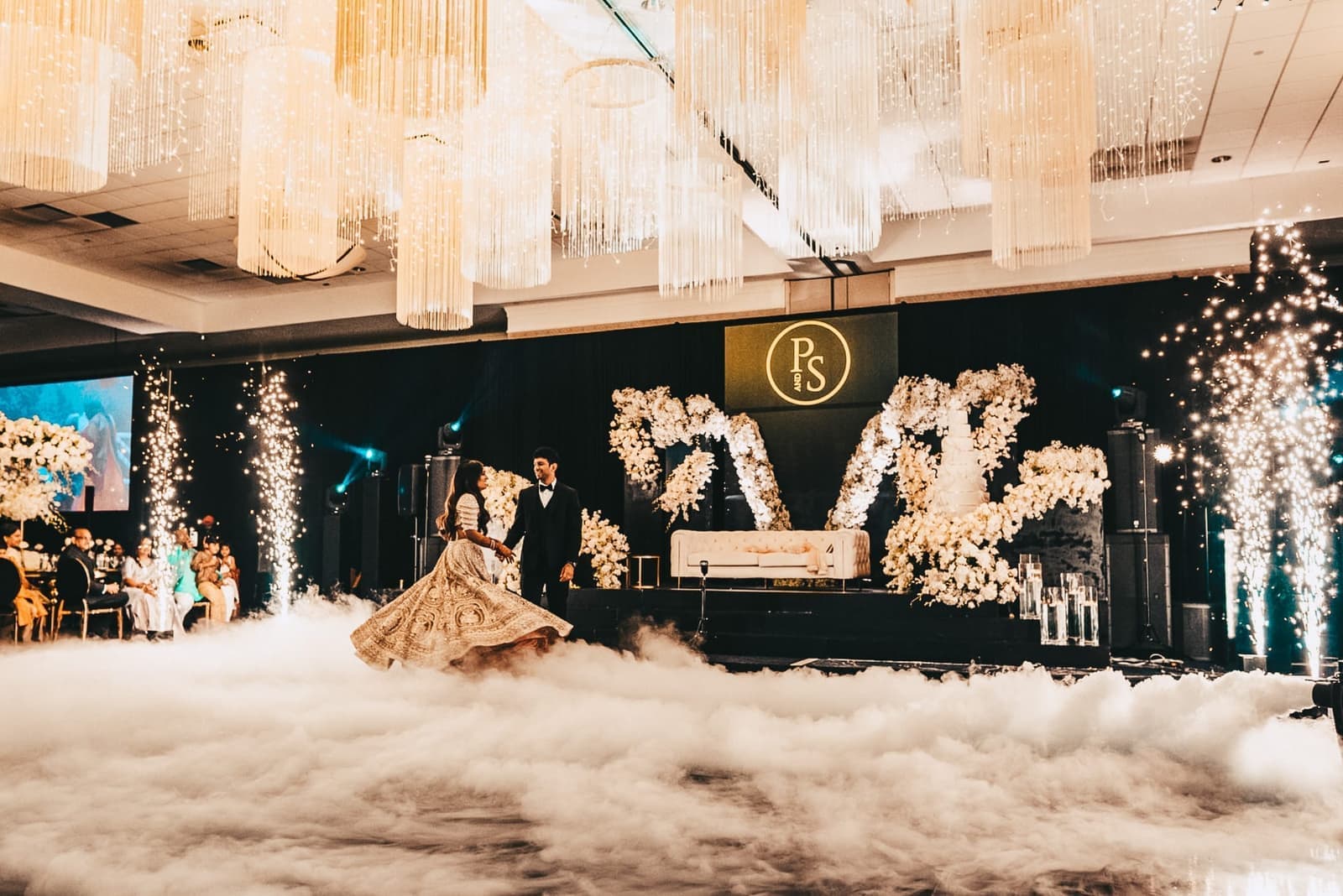 Bride twirling through a cold spark entrance under gold lighting