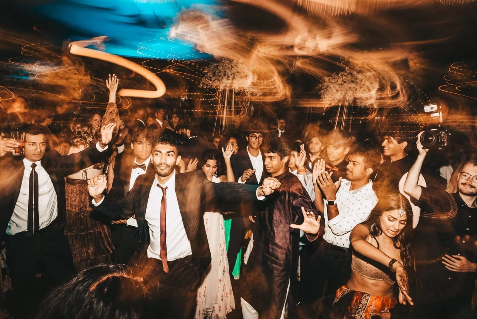 High-energy dance floor lit by moving lights and light trails at an Amped Entertainment event
