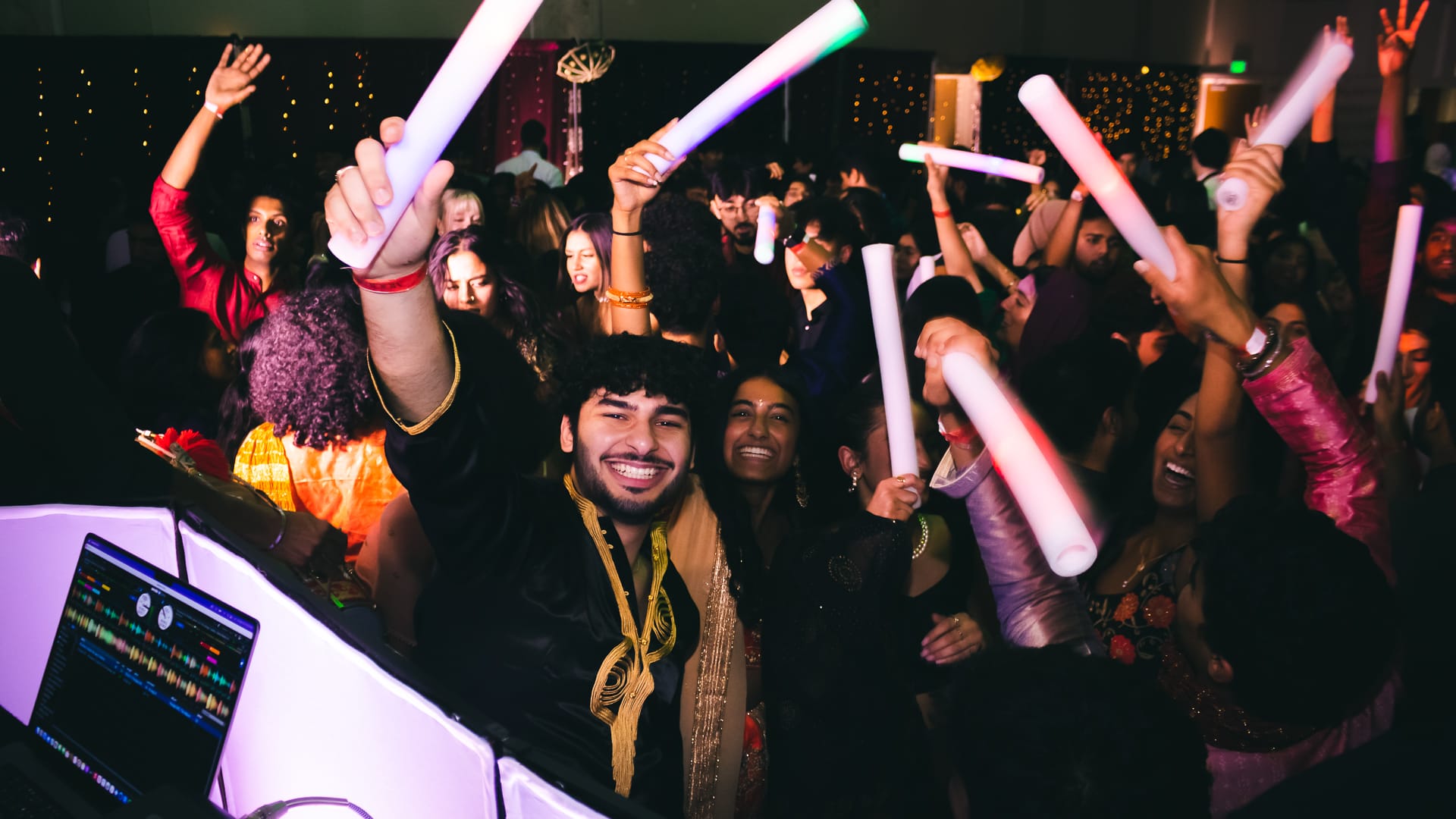 A packed campus dance floor gathered around the DJ booth