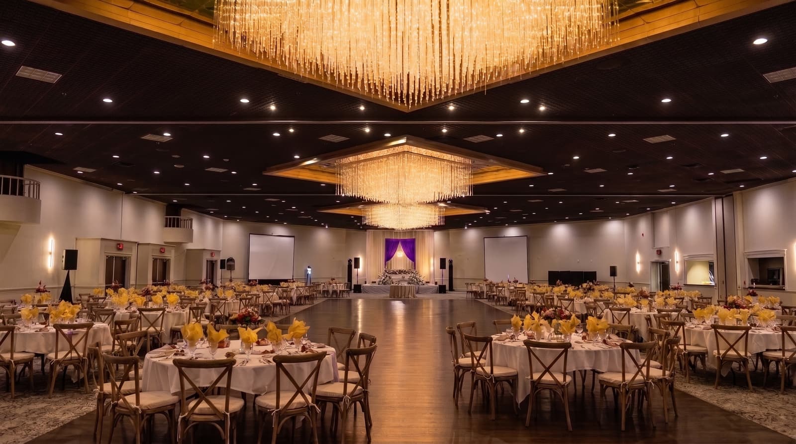 Grand wedding ballroom under soft neutral house lighting before Amped uplighting